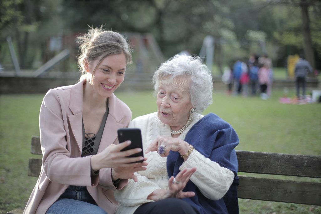 resident and woman looking at phone together