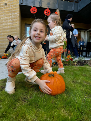 Residents, staff, and family members dressed in Halloween costumes, smiling