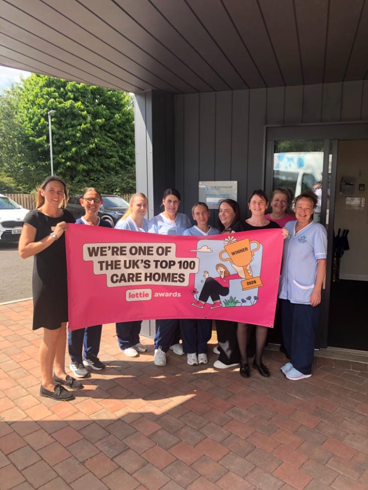 staff holding up award sign