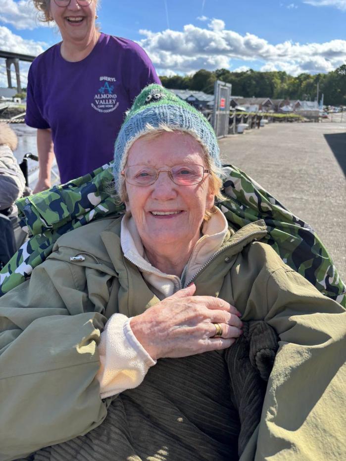 resident smiling with carer on outing at wetwheels